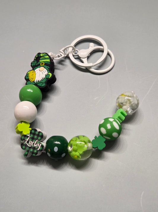 St. Patty's Day - Keychain/Purse Charm - Gnome Holding a Coin with Multiple Clover Beads and Other Beads in Various Colors of Greens, Super Cute & Fun!