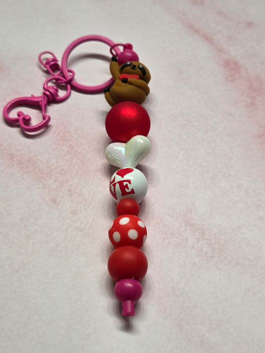 Valentine's Day - Keychain/Purse Charm - Sweet Sloth Holding Tight onto Heart, with Pink Hardware. This one has my heart! Sloths are so sweet 🦥